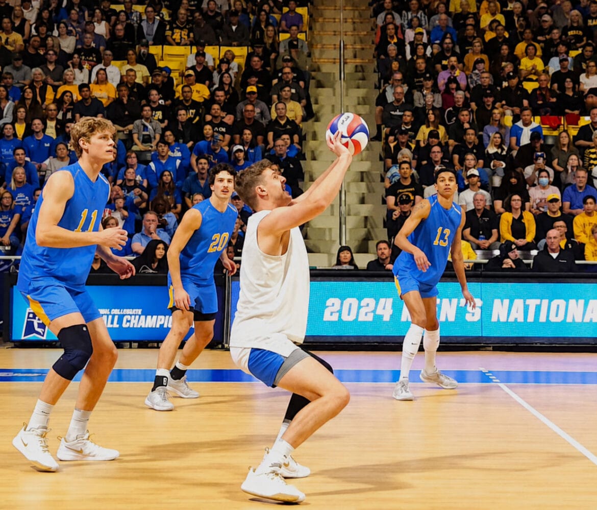 Player going for the perfect set during national championships as teammates watch